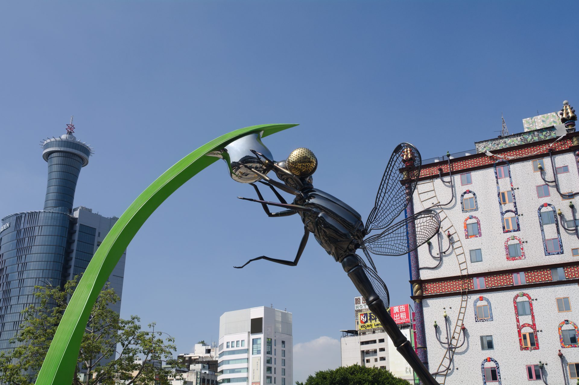 Giant dragonfly sculpture against the Taichung skyline