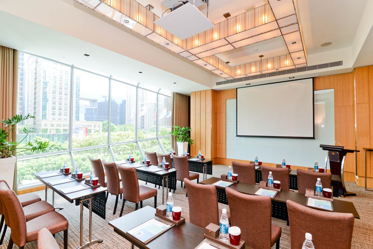 Meeting room VEE04 in classroom setup, with a projector screen and floor-to-ceiling windows